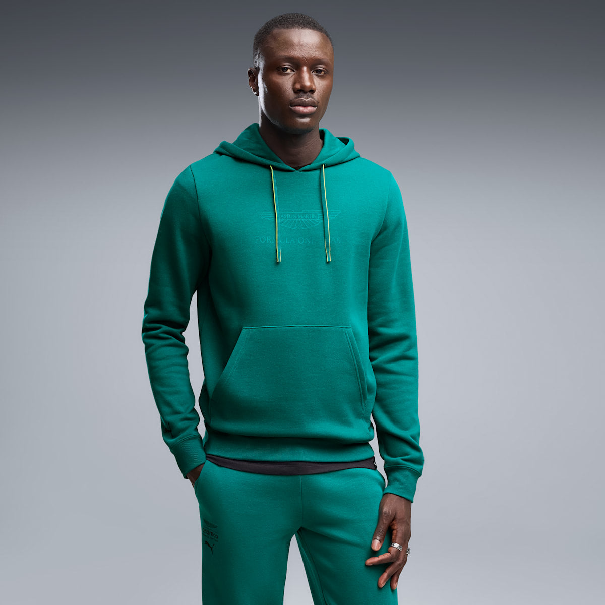 PUMA x ASTON MARTIN ARAMCO F1® TEAM Essentials Hoodie Men - Green Lux - on model