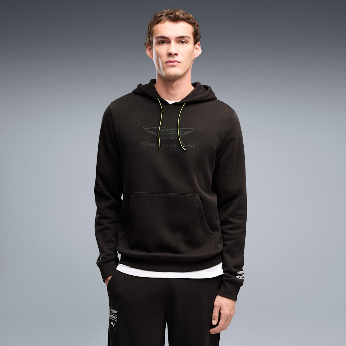 PUMA x ASTON MARTIN ARAMCO F1® TEAM Essentials Hoodie Men - PUMA Black - on model